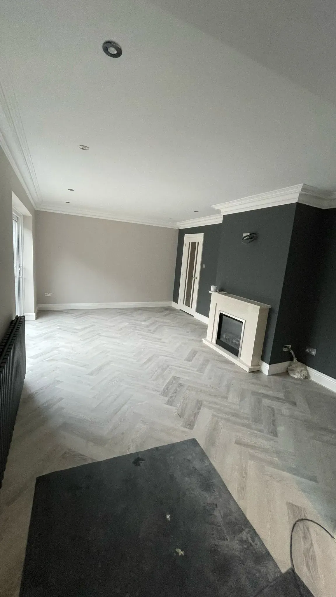 Modern home renovation in Cheltenham showing new herringbone flooring and a feature fireplace wall.