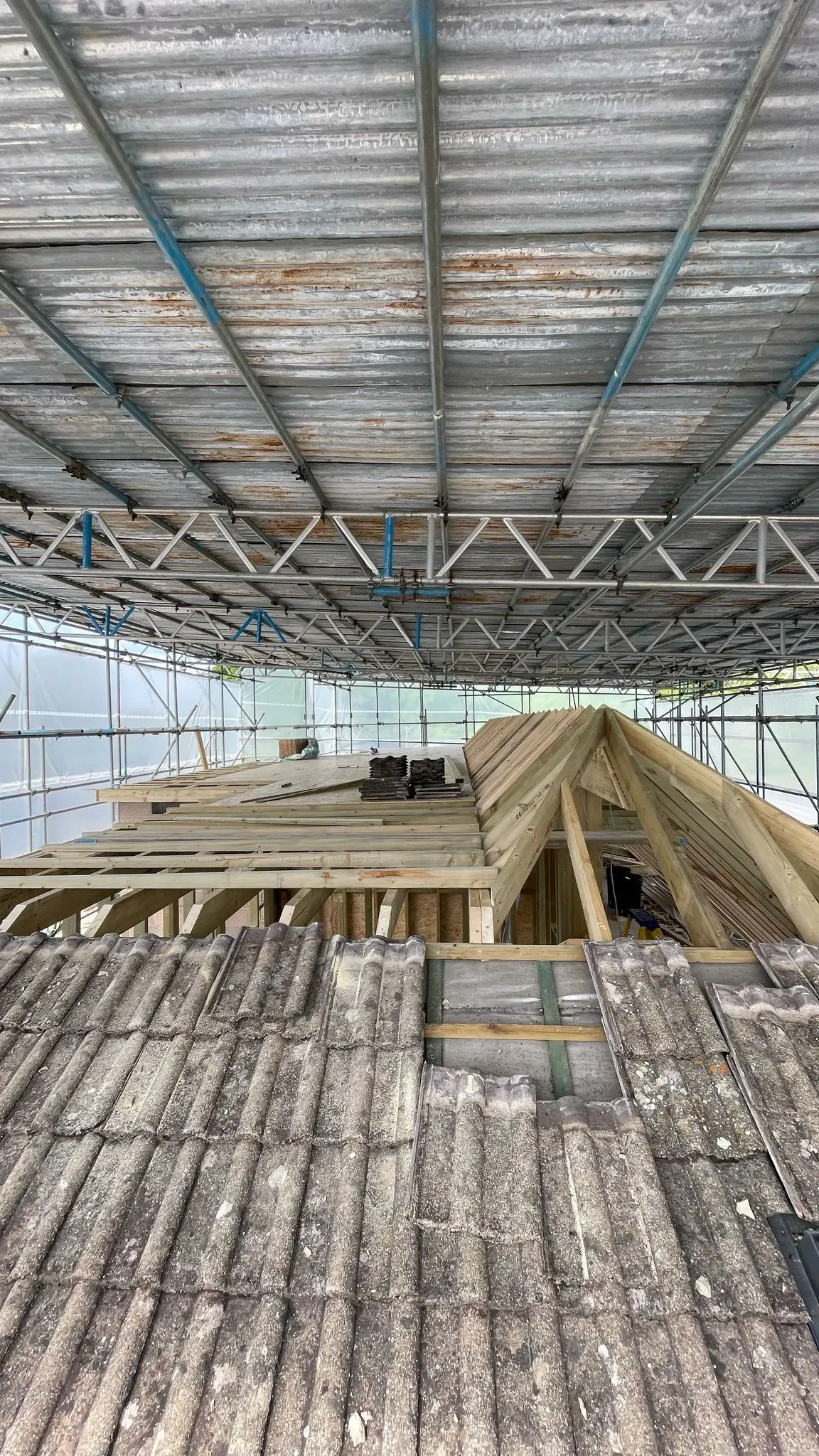 New timber roof trusses being installed on a house in Cheltenham under a temporary scaffolding roof.