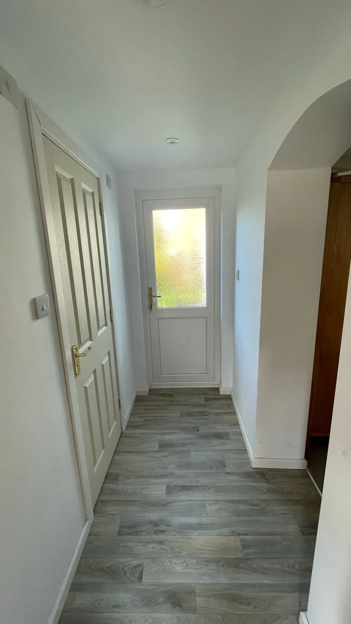 A renovated hallway with new flooring and door installations in a Cheltenham home.