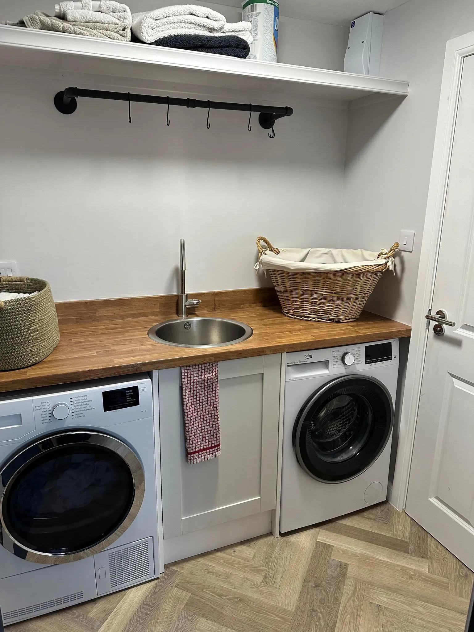 Modern utility room renovation by DP Carpentry & Building LTD in Gloucestershire, showing fitted units, appliances, and wood worktop.
