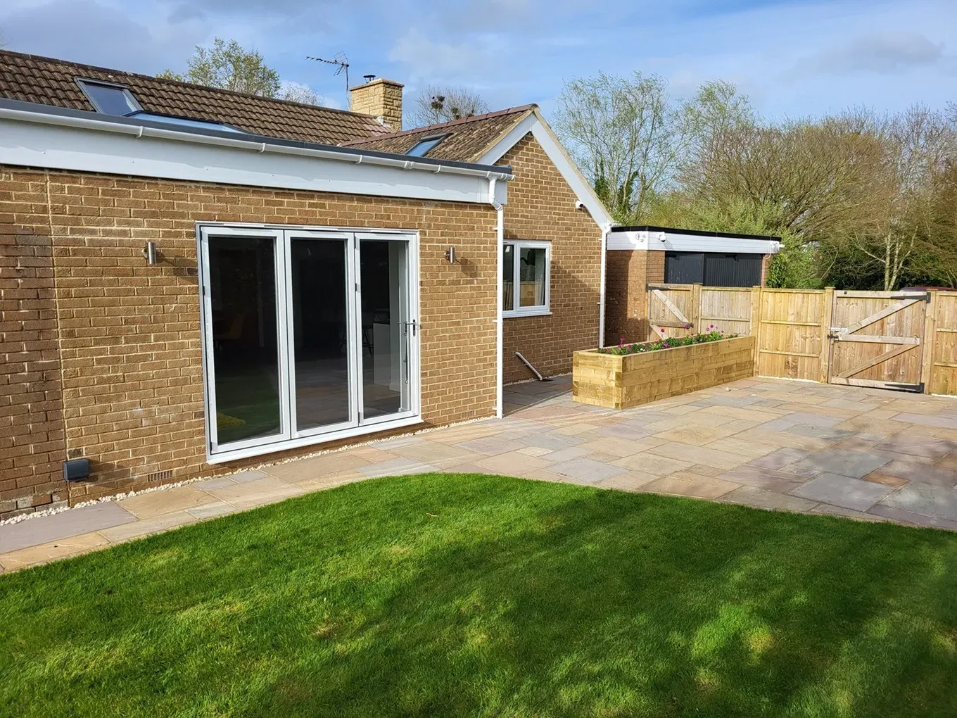 Modern home extension with bi-fold doors and a stone patio in Cheltenham