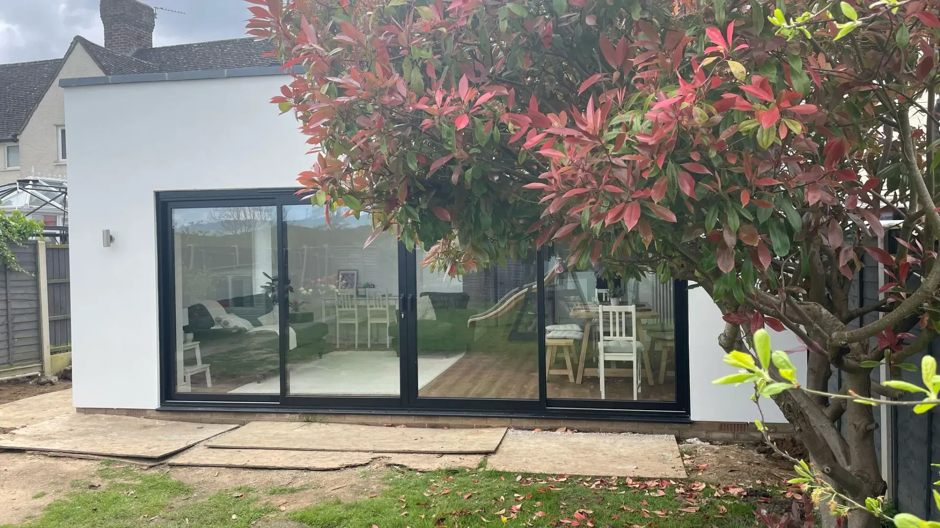A completed single-storey home extension with large sliding glass doors and white rendering by DP Carpentry and Building LTD.
